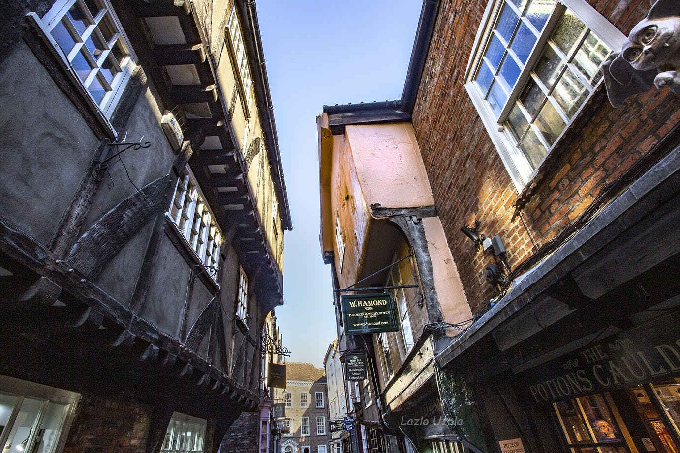 <p>York Shambles is a historic street in York, England, that features preserved medieval buildings, some dating back as far as the 14th century. The street is narrow, with many timber-framed buildings with jettied floors that overhang the street by several feet. </p><p><br></p><p>It was once known as The Great Flesh Shambles, probably from the Anglo-Saxon Fleshammels (literally flesh-shelves), the word for the shelves that butchers used to display their meat.</p><p><br></p><p>Today, the street is home to a variety of shops, eateries and attractions, such as the Ghost Shop, the Sweet Shop and the Coin Shop. It is also a popular tourist destination, as it resembles Diagon Alley from the Harry Potter series.</p><p><br></p>