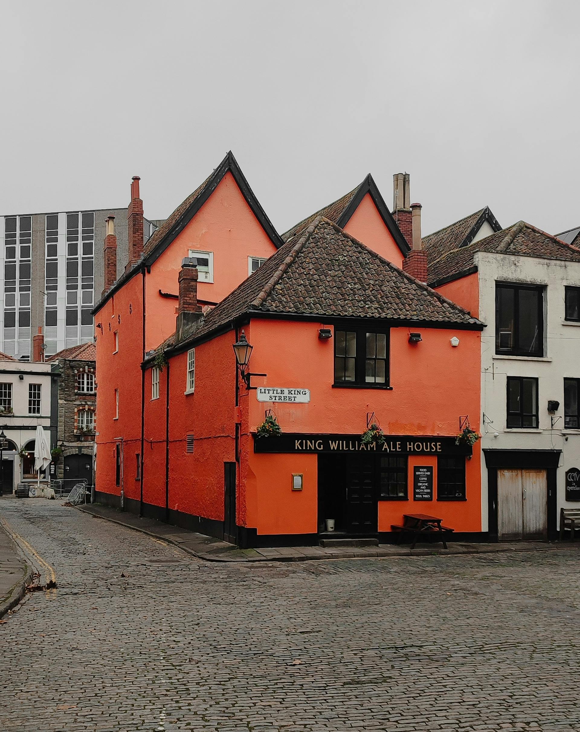 <p>The King William Ale House is a historic public house situated on King Street in Bristol, England. It dates from 1670 and was originally part of a row of three houses. The three have been designated by English Heritage as a grade II* listed building since 8 January 1959. </p><p><br></p><p>It includes a mixture of 17th-century and 18th-century features, such as timber-framed gables, sash windows, and a stone fireplace. It is currently owned and operated by Samuel Smith Old Brewery, which serves traditional English beer and ale.</p><p><br></p><p>The pub is family friendly and offers hearty home cooked food and drinks in a cosy and welcoming atmosphere. It has two entrances, one on King Street and the other on Little King Street, and has seating booths and pool tables inside. It is open from Tuesday to Sunday, with varying hours depending on the day. It has a 3.5 rating on Tripadvisor, based on 135 reviews, with mixed feedback on the service, prices, and quality of food and drinks.</p><p><br></p><p>If you are interested in visiting the King William Ale House, you can find more information on its website. You can also see some of the other pubs and restaurants on King Street, such as The Famous Royal Navy Volunteer or The Old Duke, which are part of the same historic row of buildings. King Street is a popular destination for tourists and locals alike, as it is close to the Bristol Old Vic theatre, the Harbourside, and the Queen Square park.</p><p><br></p>