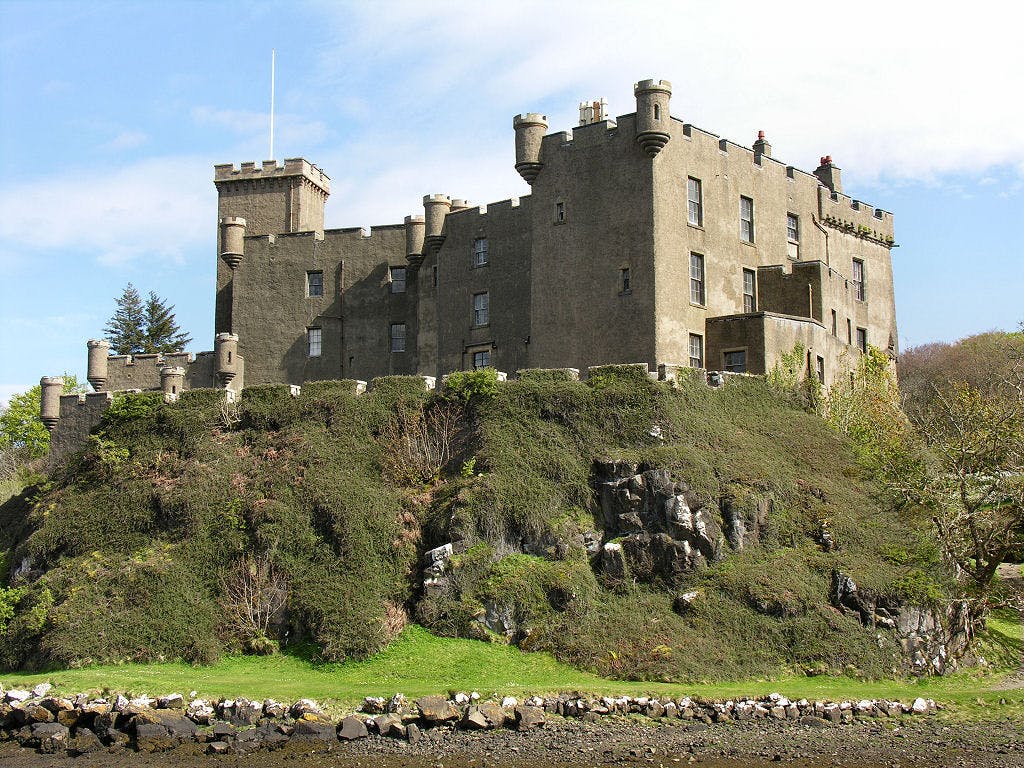 <p>Dunvegan Castle is a historic castle on the Isle of Skye in Scotland. It has been the seat of the MacLeod of MacLeod, chief of the Clan MacLeod, for over 800 years. The castle has a rich history and a collection of family heirlooms, such as the Dunvegan Cup, the Fairy Flag, and Sir Rory Mor’s Horn. The castle also has beautiful gardens and a stunning view of the Loch Dunvegan. </p><p><br></p><p><u>Here is some more information about Dunvegan Castle:</u></p><p><br></p><p>The castle was first built in the 13th century as a fortified site on a rock overlooking the sea. It was expanded and modified over the centuries, with different parts of the castle dating from different periods. The oldest part of the castle is the four-storey tower house, which was built in the late 14th century. The Fairy Tower, a separate building, was added around 1500 by Alasdair Crotach, the 8th chief. </p><p><br></p><p>In the 17th century, new ranges of buildings were constructed between the old tower and the Fairy Tower, creating a state apartment for Ruairidh Mòr, the 15th chief. In the 18th and 19th centuries, the castle was remodelled in a mock-medieval style, with the addition of battlements, a drawbridge, and a new entrance. The current appearance of the castle dates from around 1840, when the process of “baronialisation” was completed.</p><p><br></p><p>The castle is home to some of the most famous and cherished relics of the Clan MacLeod. The Dunvegan Cup is a wooden mazer bowl that was given to the clan by the O’Neills of Ulster as a token of friendship in 1493. The cup is made of oak and silver and has Celtic designs and inscriptions. The Fairy Flag is a silk banner that is said to have magical powers. According to legend, the flag was given to the clan by a fairy princess who married a MacLeod chief. The flag is believed to bring victory, fertility, and protection to the clan. The flag has been used in several battles and has many holes and tears. </p><p><br></p><p>Sir Rory Mor’s Horn is a drinking horn that was made from an ox horn in the 16th century. The horn can hold about 1.5 litres of claret and was used as a test of manhood for the clan chiefs. The chief had to drink the horn dry in one go to prove his worthiness. The horn is decorated with silver and has the MacLeod crest and motto.</p><p><br></p><p>The castle has six acres of gardens that are divided into different sections. The Round Garden is the oldest part of the garden, dating from the 18th century. It has a circular lawn surrounded by flower beds and trees. The Walled Garden is a formal garden that was created in the 19th century. It has geometric patterns of box hedges, roses, and herbs. The Water Garden is a modern garden that was designed in the 1980s. It has a series of pools, waterfalls, and bridges that create a tranquil atmosphere. The castle also has a woodland garden, a vegetable garden, and a glasshouse.</p><p><br></p><p>The castle is open to the public from April to October and offers guided tours, audio guides, and exhibitions. The castle also hosts events such as weddings, concerts, and festivals. The castle is a member of the Historic Houses Association and is a Category A listed building.</p>