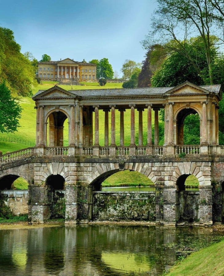 <p>The Palladian Bridge in the grounds of Prior Park, located in Bath, England, is a captivating architectural gem. Let’s delve into its fascinating history:</p><p><br></p><p><strong>Design and Significance:</strong></p><p><br></p><p>The Palladian Bridge was built in 1755 and is an elegant example of Palladian architecture. This style draws inspiration from the works of the 16th-century Venetian architect Andrea Palladio and gained popularity in England during the 18th century.</p><p><br></p><p>It stands as the last of its kind in England, making it a unique and cherished feature.</p><p><br></p><p>The bridge is situated amidst a series of lakes within the Prior Park Landscape Garden, which was designed by the poet Alexander Pope and the renowned landscape gardener Capability Brown.</p><p><br></p><p><strong>Technical Details:</strong></p><p><br></p><p>Official Listing: The Palladian Bridge is a Grade I listed building on the National Heritage List for England.</p><p>Location: You can find it at Ralph Allen Drive, Bath BA2 5AH4.</p><p><br></p><p>Opening Hours: It’s open daily from 10:00 AM to 5:00 PM4.</p><p><br></p><p>Contact Number: For more information, you can call 01225 8339774</p><p><br></p><p><strong>Fun Fact:</strong></p><p><br></p><p>Only four Palladian bridges of this design exist worldwide, and the one at Prior Park is a remarkable survivor5</p><p><br></p><p>Next time you’re in Bath, don’t miss the chance to visit this picturesque bridge and immerse yourself in its historical charm! 🌿🏛️</p>
