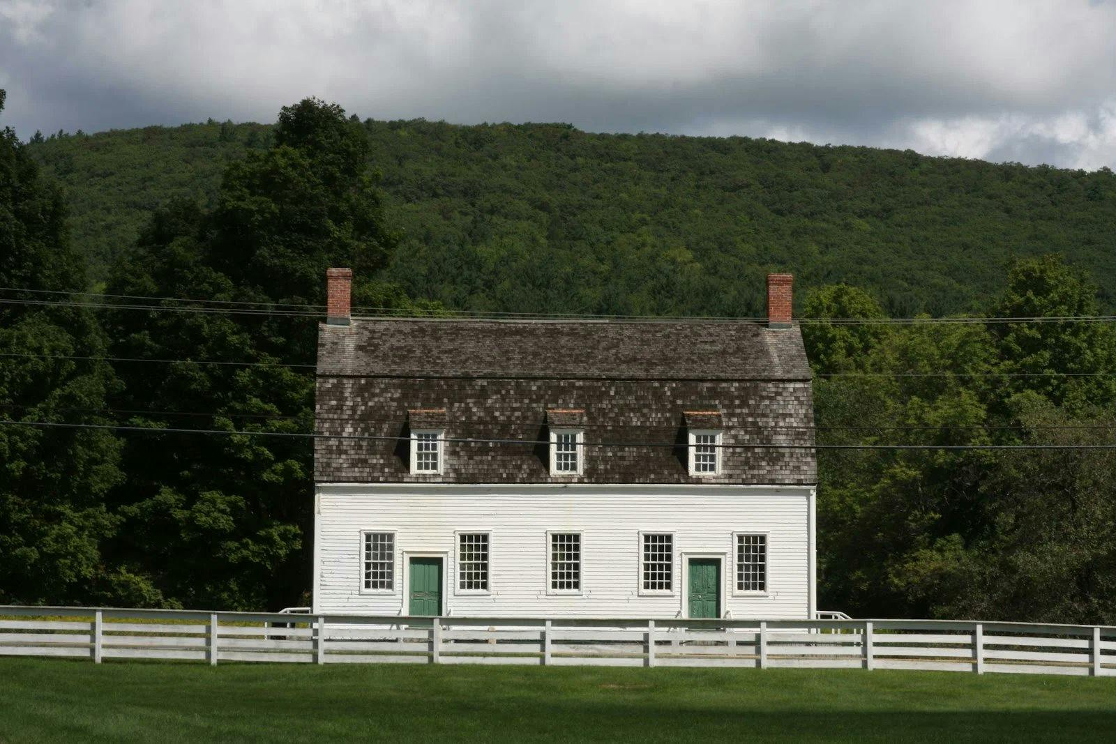 <h3><strong>Origins and Historical Significance</strong></h3><p>The story of Hancock Shaker Village unfolds like a well-preserved chapter from the past. Imagine lush green landscapes, rustic wooden structures, and a community bound by faith and hard work. Here’s a glimpse into its fascinating history:</p><h4><strong>1. The Birth of a Commune</strong></h4><p>In the late <strong>1780s</strong>, the Shakers—a religious sect known for their simplicity, craftsmanship, and communal living—established Hancock Shaker Village. The village spanned across the towns of <strong>Hancock, Pittsfield, and Richmond</strong>. These devoted individuals believed in equality, celibacy, and a life dedicated to God.</p><h4><strong>2. A Living-History Museum</strong></h4><p>Fast forward to today, and Hancock Shaker Village stands as a <strong>living-history museum</strong> that transports visitors back in time. As you step onto its sprawling <strong>750-acre</strong> grounds, you’ll encounter a world where the past comes alive:</p><ul><li><strong>Authentic Shaker Buildings</strong>: Wander through <strong>20 meticulously restored Shaker buildings</strong>, each echoing with whispers of the past. From the simple meetinghouse to the functional barns, these structures reveal the Shakers’ commitment to craftsmanship and practicality.</li><li><strong>Costumed Interpreters</strong>: Meet friendly interpreters clad in period attire. They share stories, demonstrate traditional crafts, and invite you to participate in daily tasks. It’s like stepping into a time capsule.</li><li><strong>Shaker Artifacts</strong>: The village houses an impressive collection of <strong>Shaker furniture, tools, and artifacts</strong>. Rotating exhibits showcase their exquisite craftsmanship and ingenious designs. Don’t miss the iconic ladder-back chairs and intricately woven baskets.</li><li><strong>A Farmstead Experience</strong>: Stroll along the <strong>mile-long hiking trail</strong> that winds through meadows and woodlands. Along the way, you’ll encounter a <strong>working farm</strong>—complete with heritage-breed livestock and vibrant gardens. The Shakers were skilled farmers, and their legacy lives on here.</li><li><strong>The Simple Life</strong>: The Shakers believed in simplicity. Their furniture, architecture, and lifestyle reflected this ethos. As you explore, notice the clean lines, functional designs, and absence of unnecessary ornamentation.</li></ul><h4><strong>3. Practical Details</strong></h4><ul><li><strong>Location</strong>: 1843 W Housatonic St, Pittsfield, MA, 01201</li><li><strong>Opening Hours</strong>: Monday to Friday, 9:00 AM to 5:00 PM</li><li><strong>Phone Number</strong>: (413) 443-0188</li></ul><h4><strong>Visitor Reviews</strong></h4><p>With a stellar rating of <strong>4.5 stars</strong> based on <strong>803 reviews</strong>, Hancock Shaker Village has left an indelible mark on countless visitors. Whether you’re a history enthusiast, an architecture lover, or simply curious about the Shaker way of life, this village promises an enriching experience.</p><p><br></p><p>So, pack your imaginary bags, step into your mental time machine, and let Hancock Shaker Village weave its magic. 🕊️✨</p>